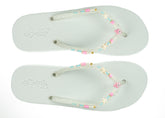 Pair of light blue flip-flops with decorative straps on a white background