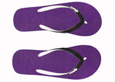 Purple flip-flops with white soles and black straps on a white background