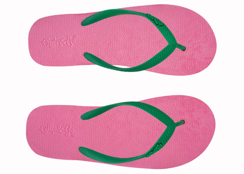 Pink flip-flops with green straps on a white background