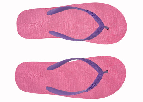 Pair of pink flip-flops with purple straps on a white background