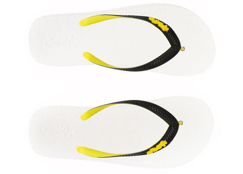 White flip-flops with black straps and yellow accents on a white background