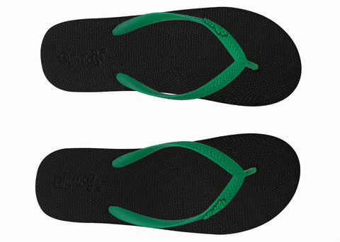 Black flip-flops with green straps on a white background