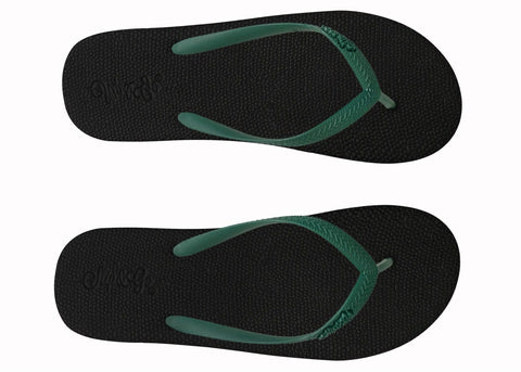 Black flip-flops with green straps on a white background